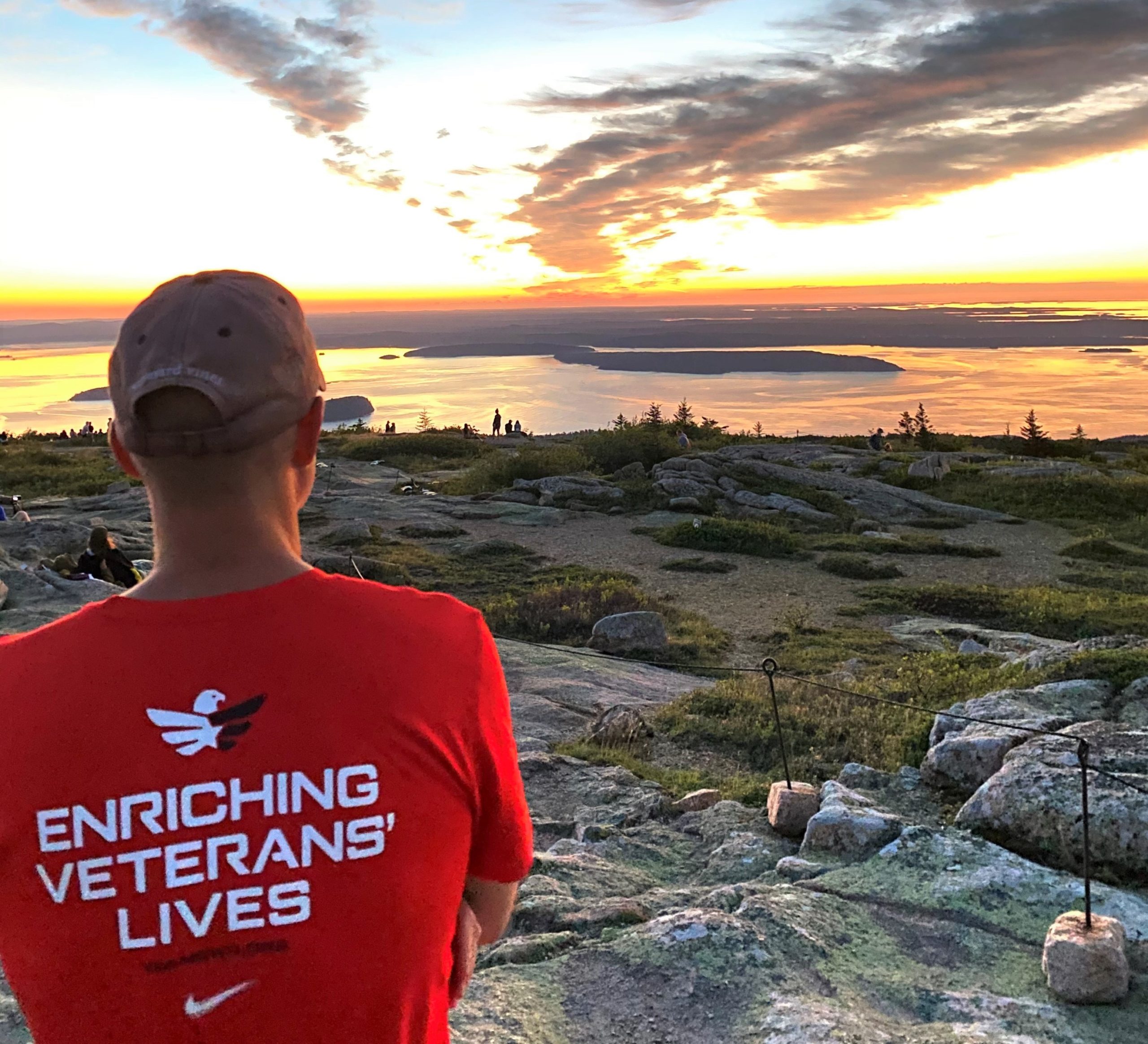 homme vétéran faisant face au loin sur une montagne regardant le coucher du soleil