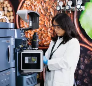 mujer científica trabajando con equipos frente a las imágenes de los recursos naturales