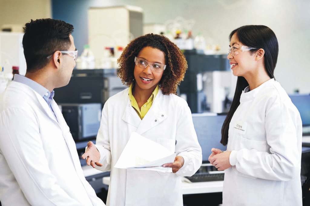 two women in lab coats speaking