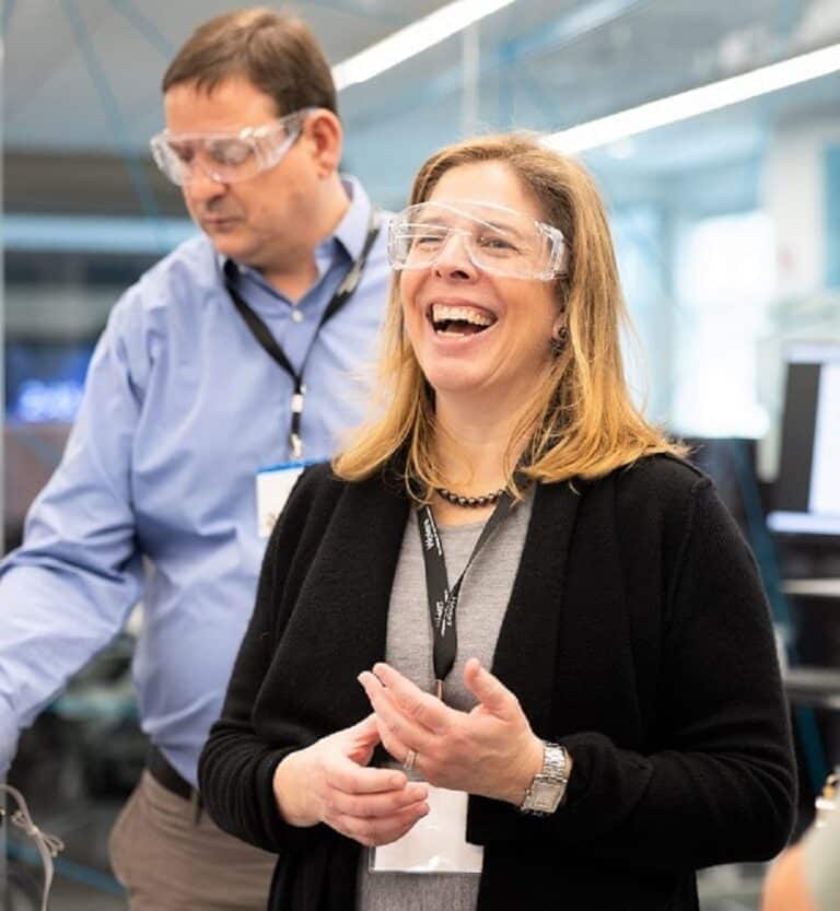 belinda hyde avec des lunettes de protection dans un laboratoire souriant