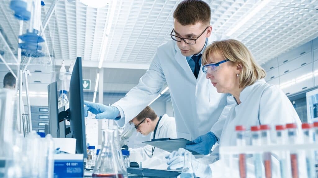in modern laboratory senior female scientist has discussion with another male scientist