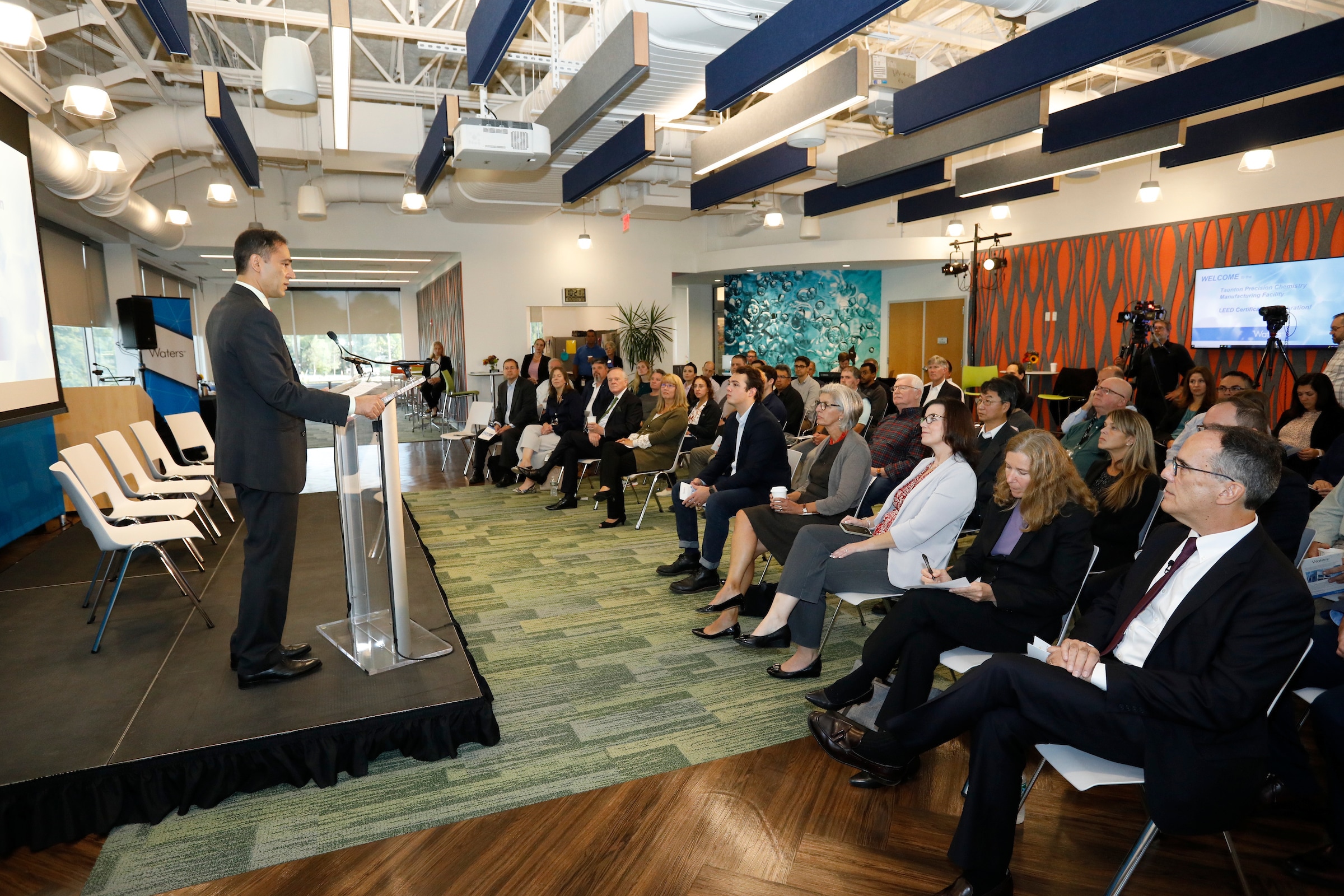 le PDG d'water s'adresse à la foule dans le hall d'entrée de l'immeuble