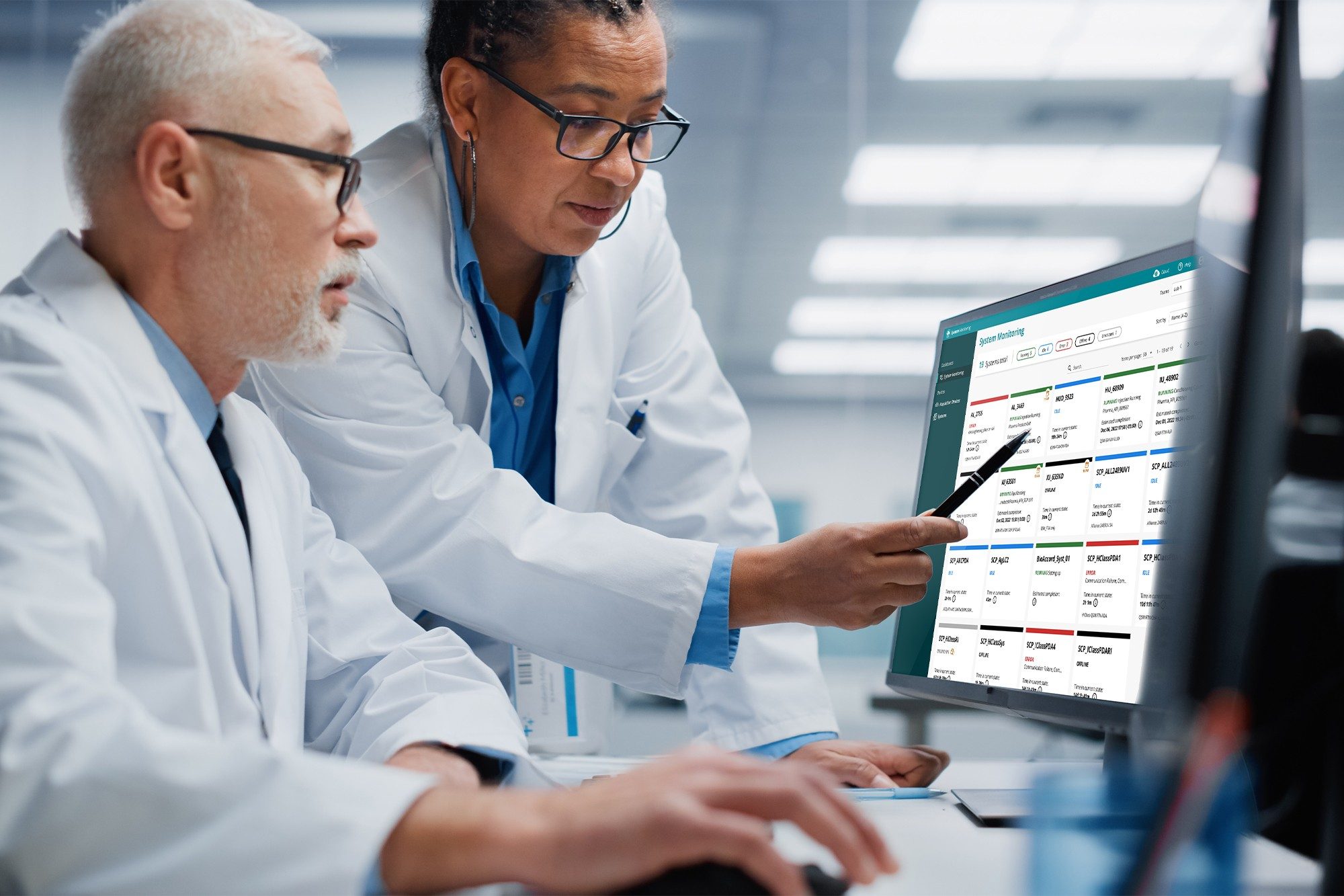 Two scientists on computer using waters_connect System Monitoring