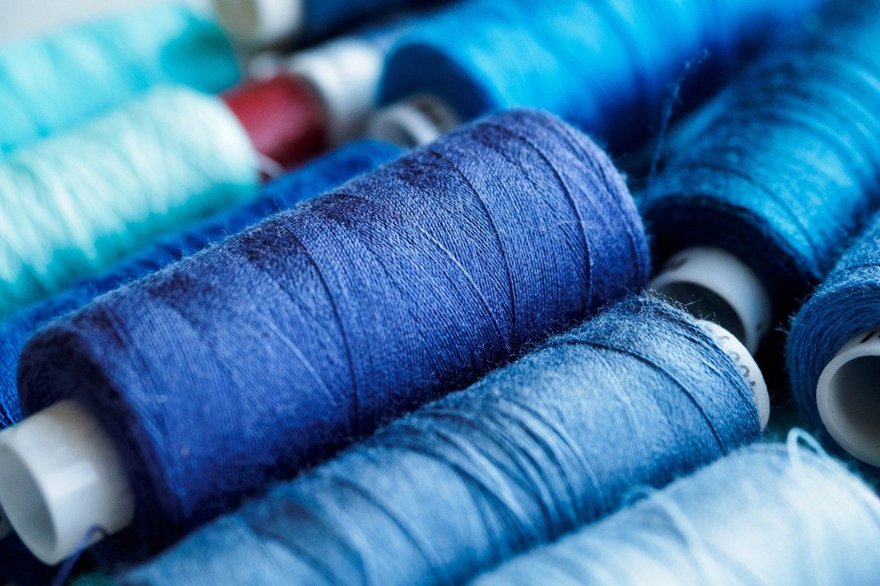 Bobbins of blue and purple thread for sewing