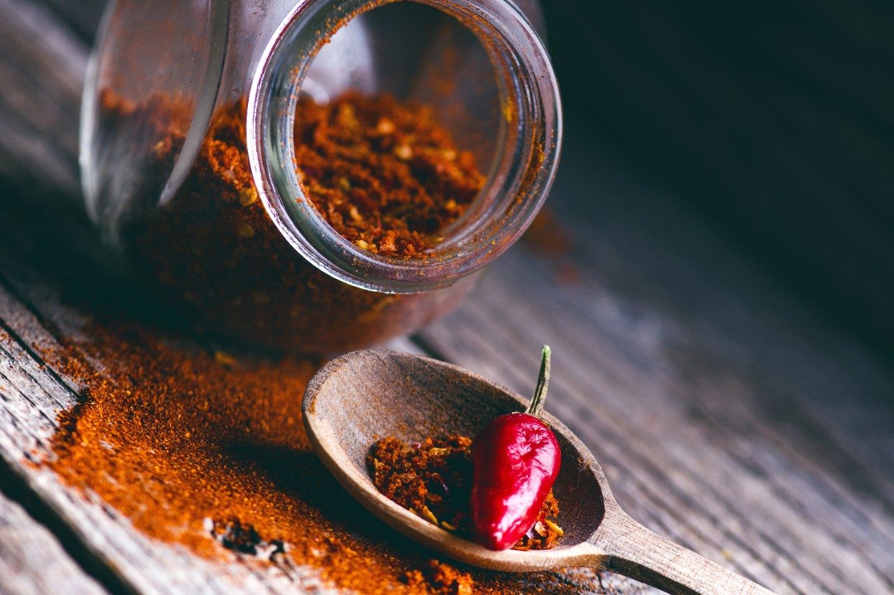 Red chilli peppers on a wooden spoon; capsaicin
