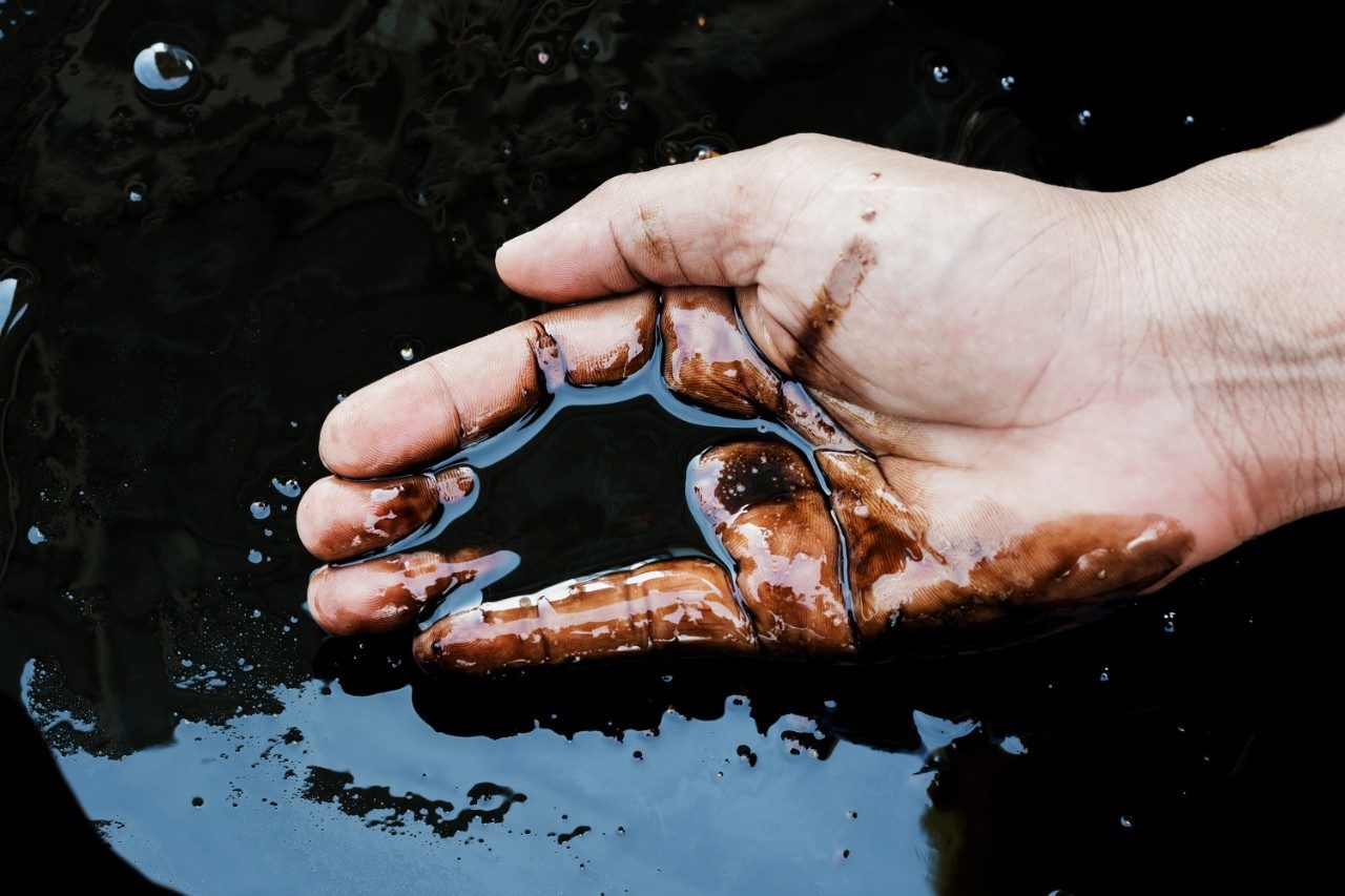 Crude oil spill in hand
