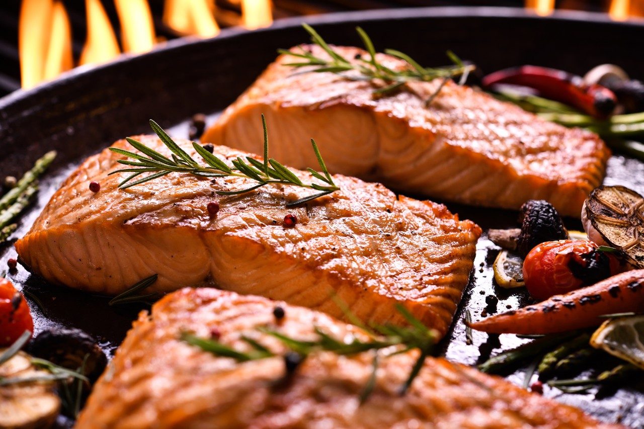 Grilled salmon fish with vegetables in pan