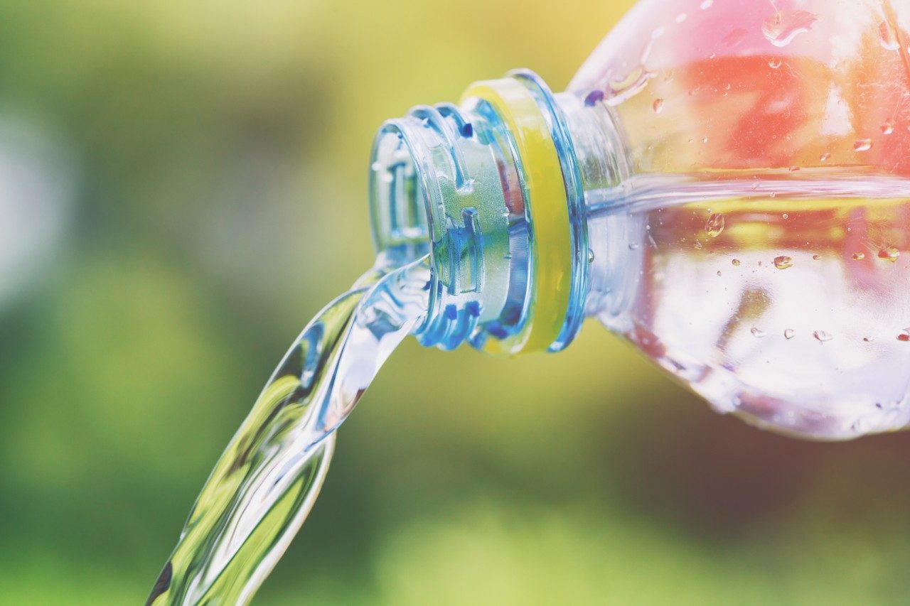 Flavored water pouring from plastic bottle