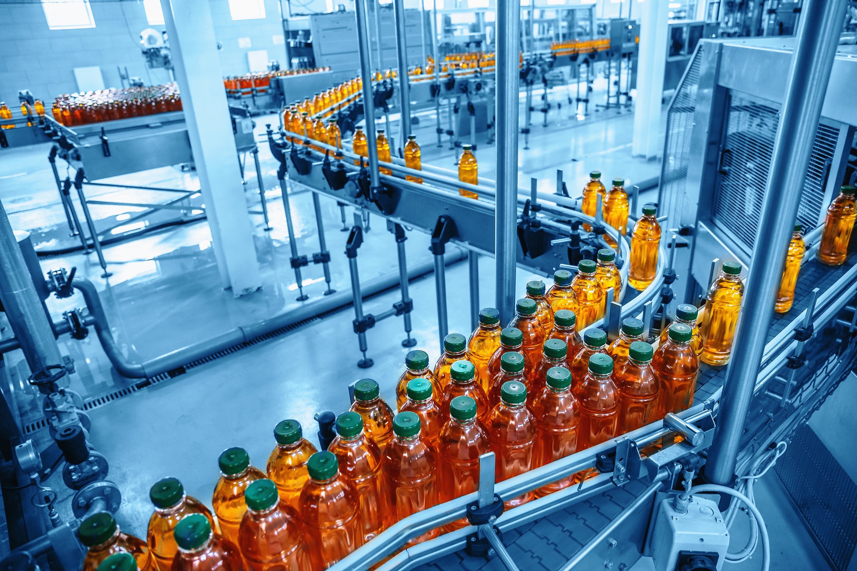 Conveyor belt, juice in bottles on beverage plant or factory interior