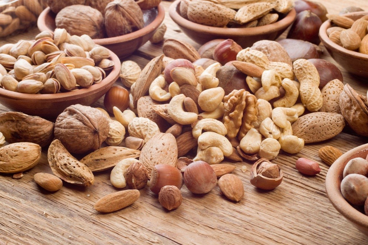 Mixed nuts of almonds, cashews, pistachios, hazelnuts on wood table
