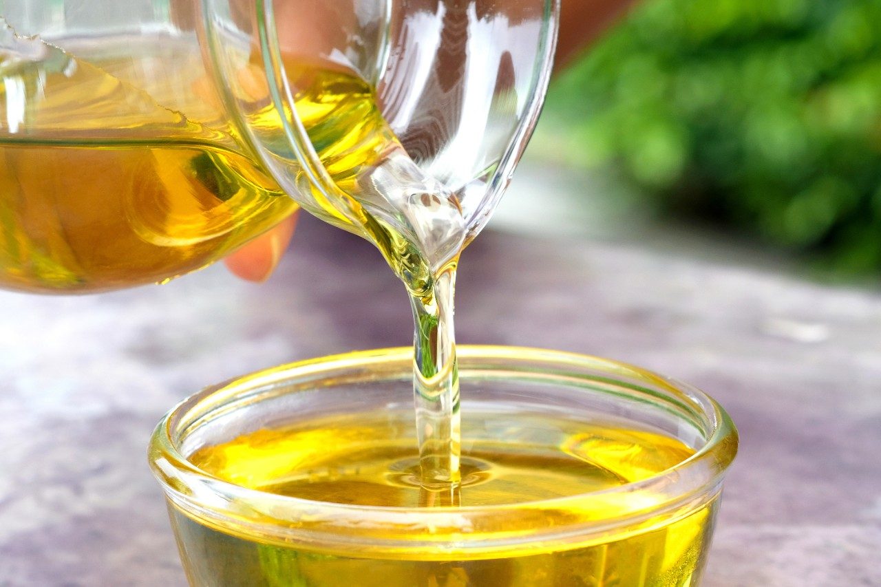 Pouring olive oil into a glass bowl