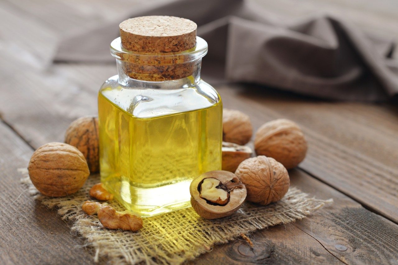Walnut oil and walnuts on wood table