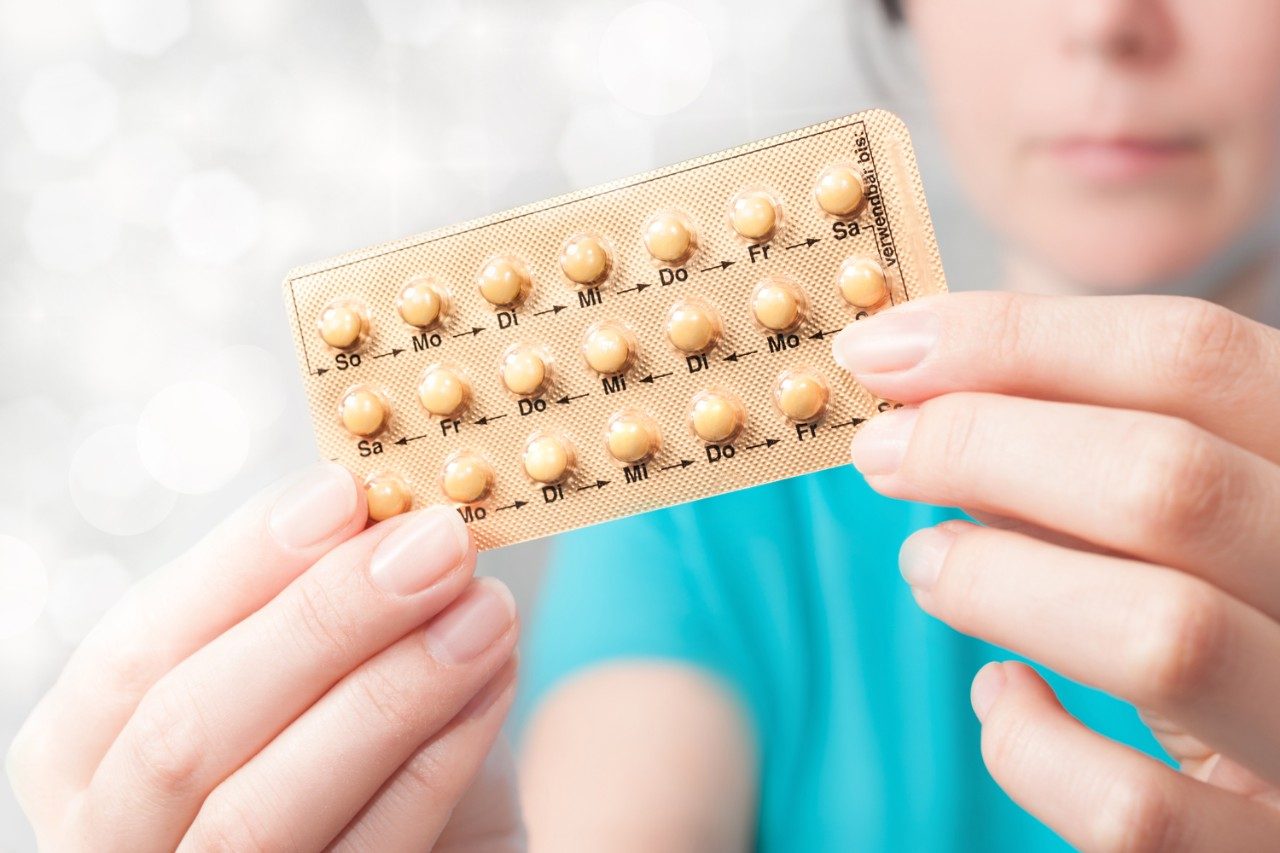 Woman holding birth control pills