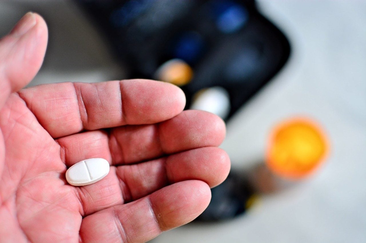 Elderly hand holding diabetes pill Glimepiride