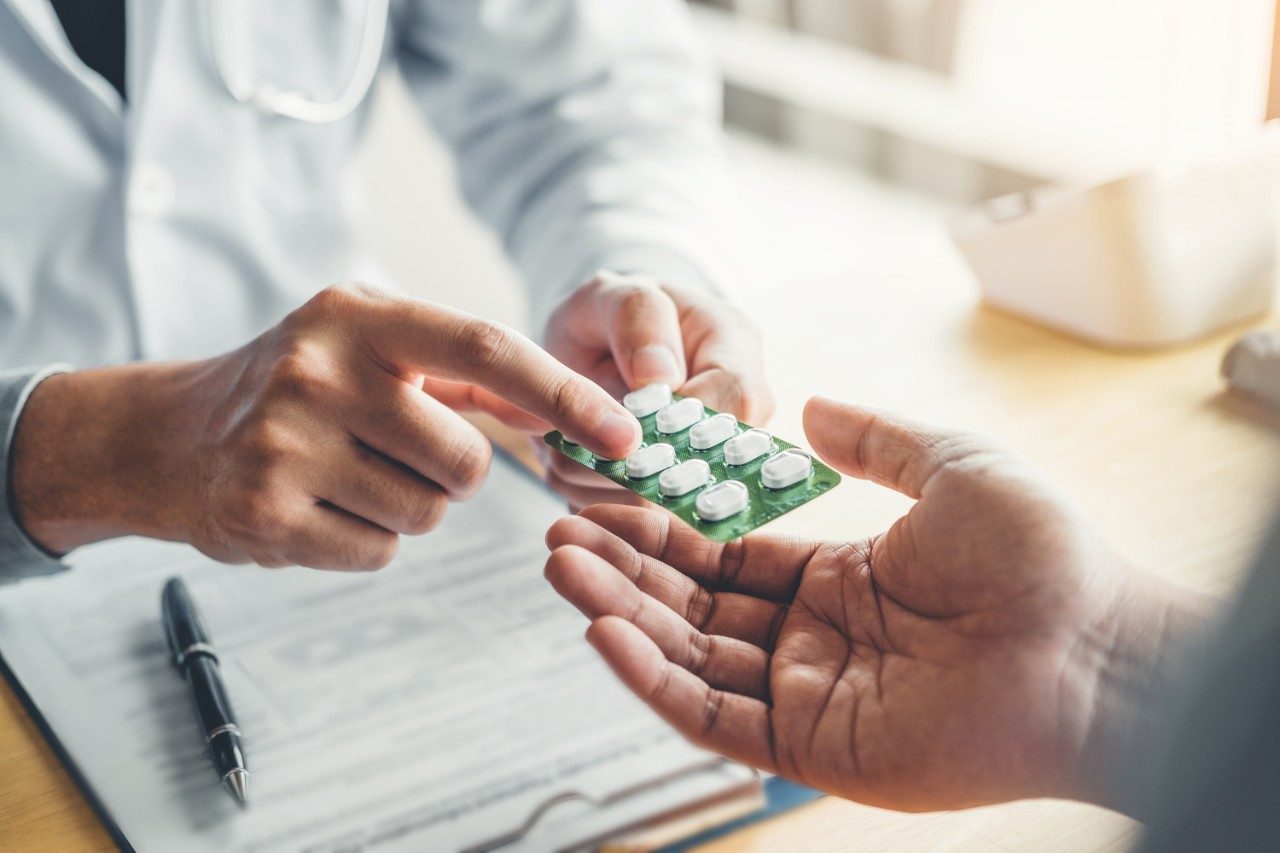 Doctor or physician recommend pills medical prescription to male patient