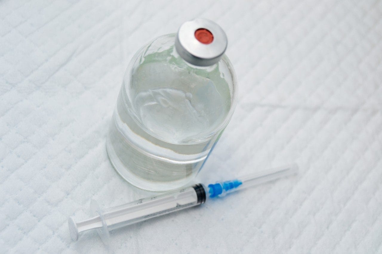 Vial with clear drug solution and a syringe