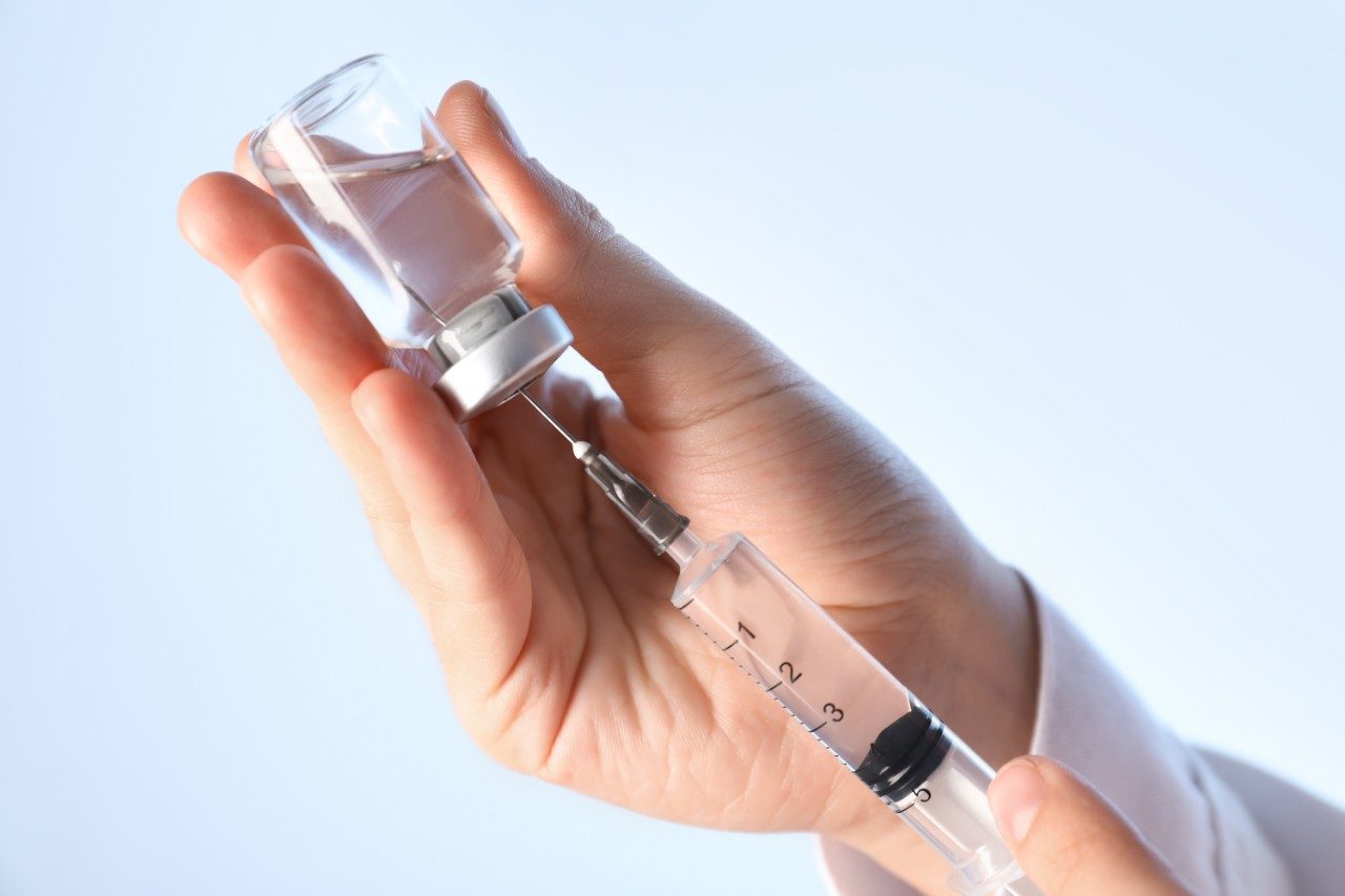 Doctor preparing syringe for injection