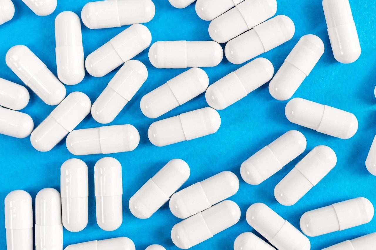Lot of white capsules as medical background
