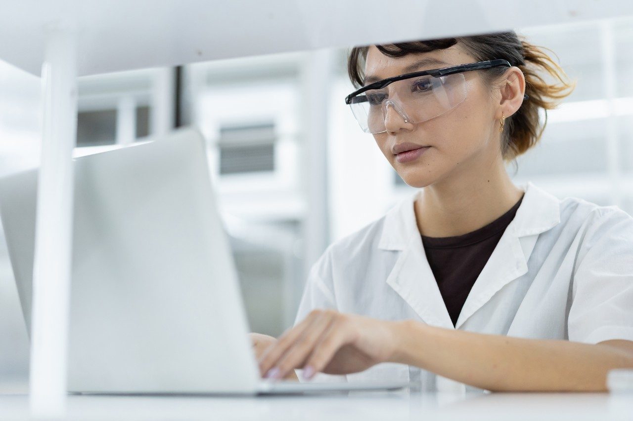 Female scientist working on laptop in laboratory