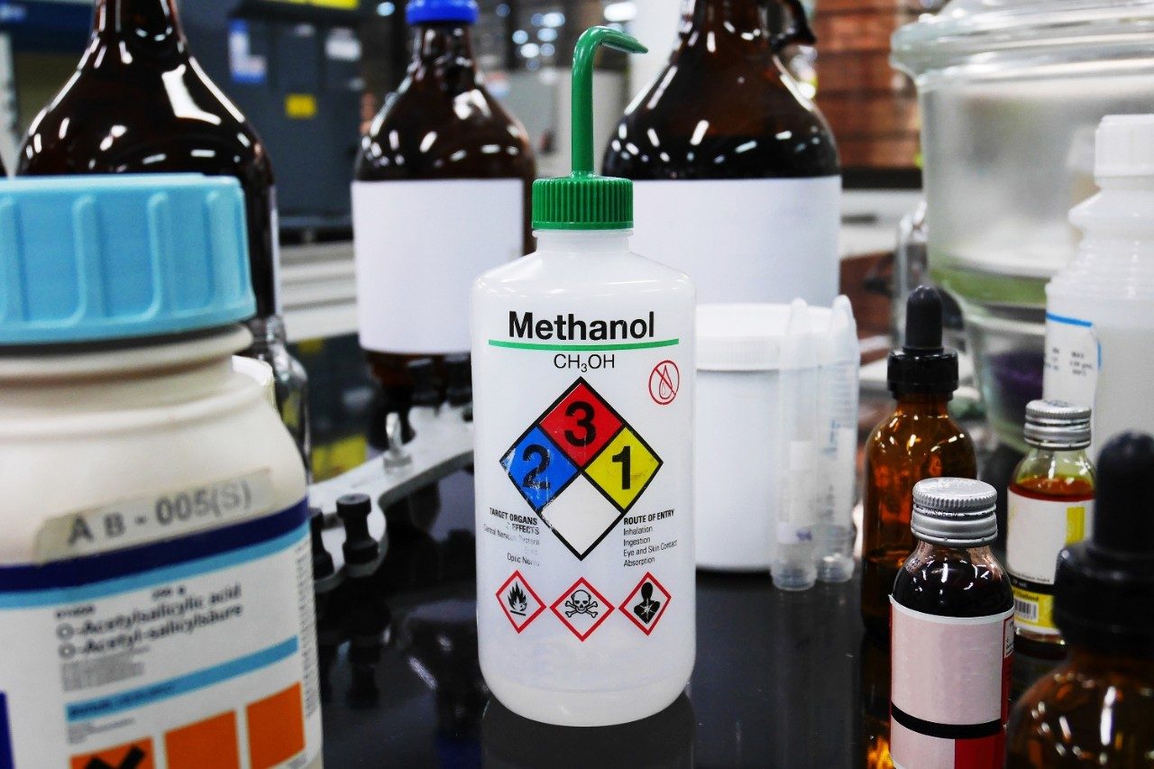 Methanol bottle and chemicals with hazard symbols